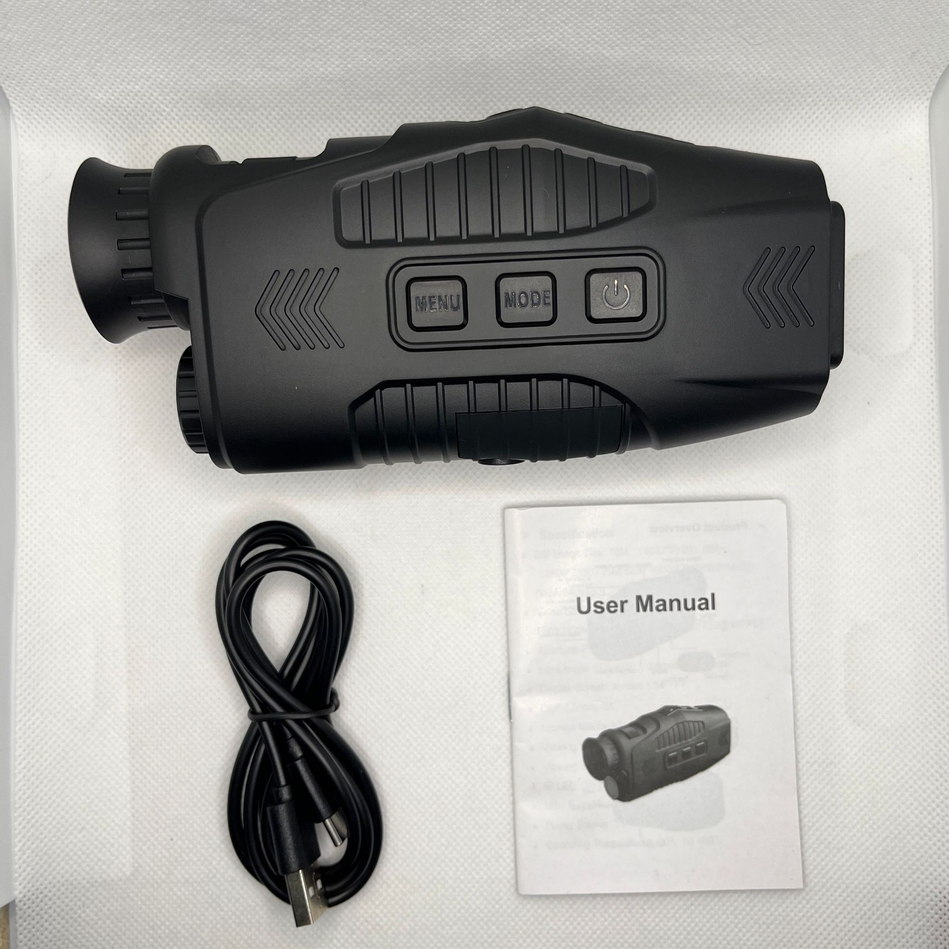 A comprehensive monocular usage manual lies beside the sleek monocular and its accompanying cable, providing essential guidance for optimal operation and viewing experiences.