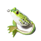 Close-up of a lifelike green frog fishing lure with red eyes, spotted body, and soft legs designed for bass and pike fishing.
