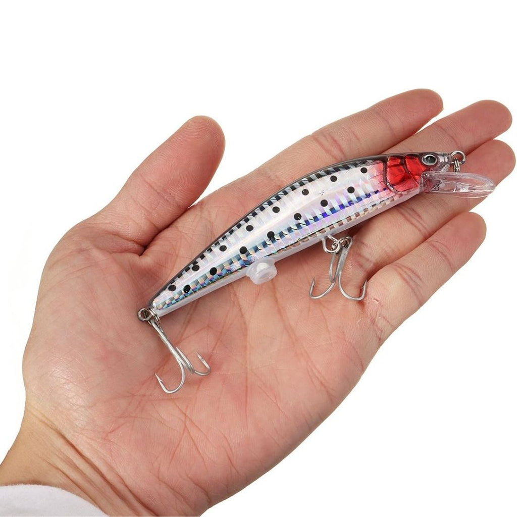 Fishing lure held in a hand against a white background