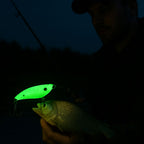 Fishing lure glowing green held by a person at night
