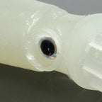 Close-up of a white plastic object with a black circular feature on a gray background